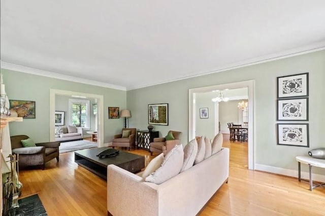 living room with light hardwood / wood-style flooring, a chandelier, and crown molding