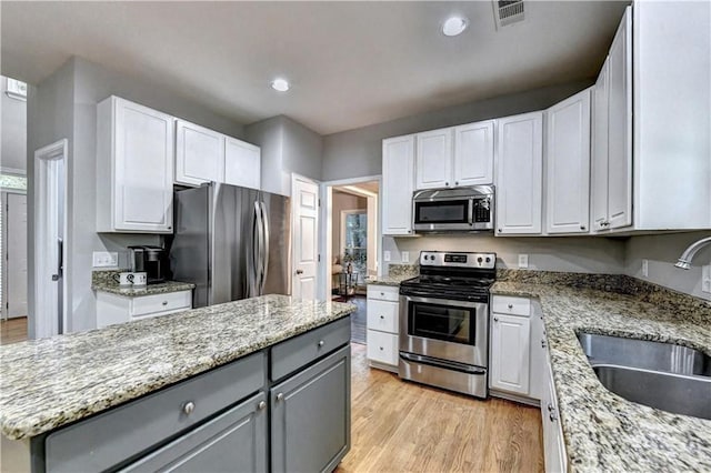 6520 Fairfield Trce, Suwanee, GA 30024 - kitchen with stainless steel appliances, gray cabinetry, white cabinetry, light wood-type flooring, and recessed lighting