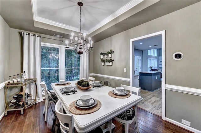 6520 Fairfield Trce, Suwanee, GA 30024 - dining area with a chandelier, a tray ceiling, dark wood-type flooring, and ornamental molding