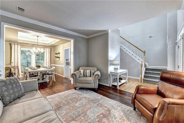 6520 Fairfield Trce, Suwanee, GA 30024 - living area with wood finished floors, a chandelier, stairway, crown molding, and a raised ceiling