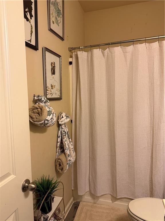 2979 Dungeness Dr, Douglasville, GA 30135 - bathroom featuring toilet and shower / bath combination with curtain