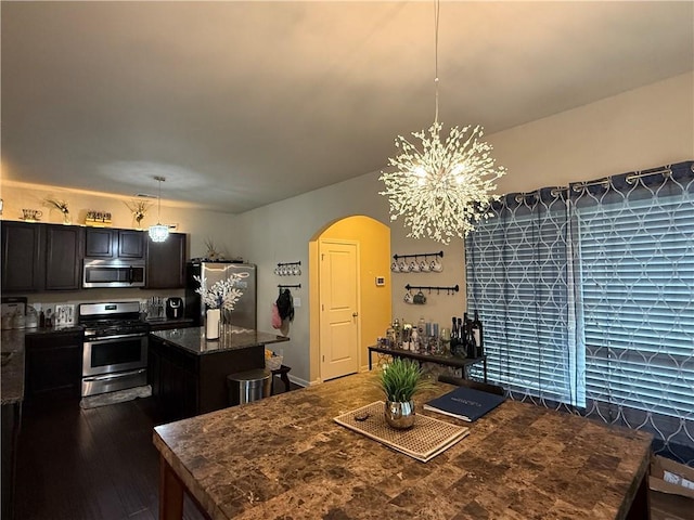2979 Dungeness Dr, Douglasville, GA 30135 - dining room featuring arched walkways, a chandelier, and dark wood-style floors