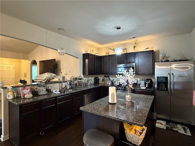 2979 Dungeness Dr, Douglasville, GA 30135 - kitchen with stainless steel appliances, a peninsula, dark stone countertops, dark wood-style flooring, and pendant lighting