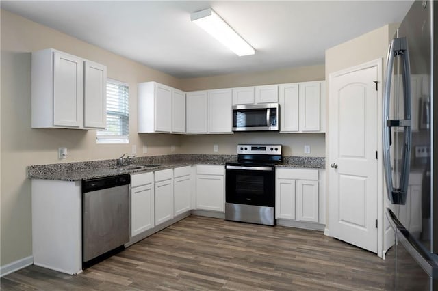 290 Middleton Ct, Chatsworth, GA 30705 - kitchen featuring appliances with stainless steel finishes, dark wood-type flooring, white cabinets, and dark stone counters