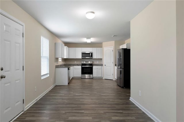 290 Middleton Ct, Chatsworth, GA 30705 - kitchen with stainless steel appliances, white cabinetry, dark wood finished floors, and dark countertops