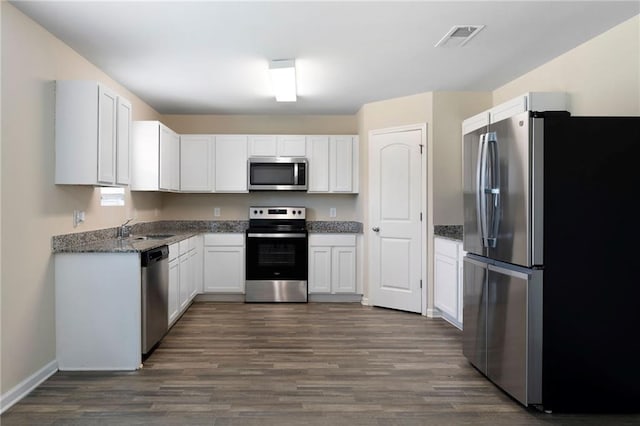 290 Middleton Ct, Chatsworth, GA 30705 - kitchen featuring appliances with stainless steel finishes, dark wood-type flooring, white cabinetry, and dark stone counters