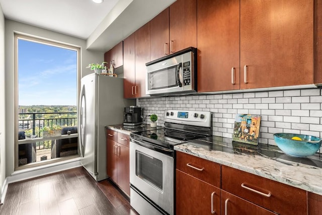 kitchen with backsplash, stainless steel appliances, dark wood-type flooring, and light stone counters