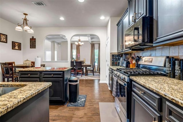 29 Madrid Ave, Newnan, GA 30263 - kitchen featuring appliances with stainless steel finishes, arched walkways, a chandelier, light stone counters, and recessed lighting