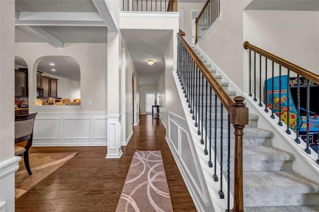29 Madrid Ave, Newnan, GA 30263 - foyer featuring dark wood-style flooring, wainscoting, stairway, beam ceiling, and arched walkways