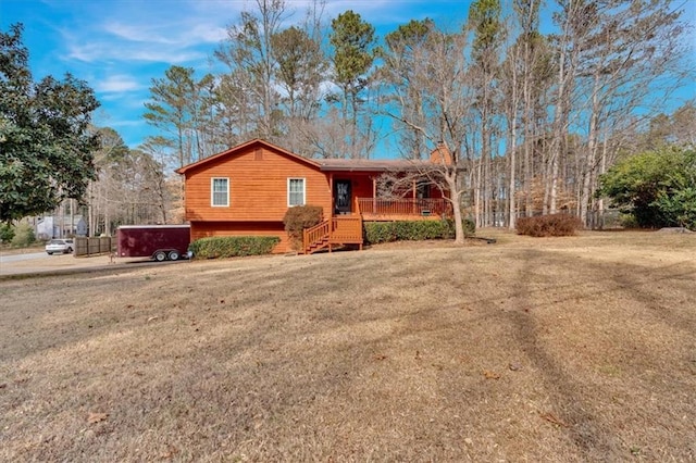 view of front of house featuring a porch, a hot tub, and a front yard