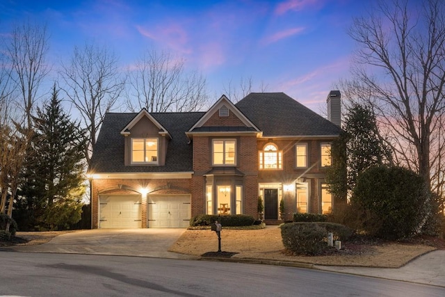 view of front of property featuring a garage, brick siding, driveway, roof with shingles, and a chimney