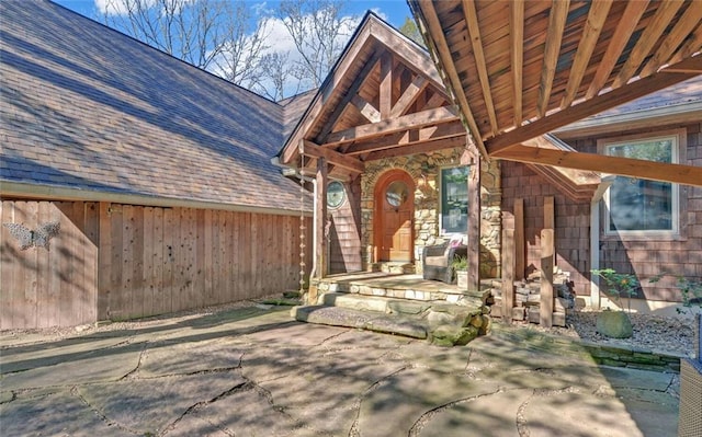 doorway to property with a shingled roof