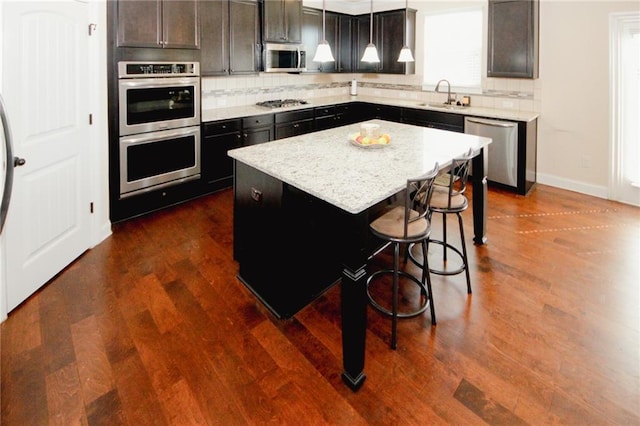 4594 Marching Ln, Fairburn, GA 30213 - kitchen with a center island, hanging light fixtures, decorative backsplash, appliances with stainless steel finishes, and a sink