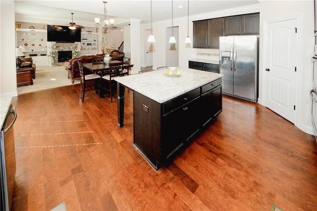 4594 Marching Ln, Fairburn, GA 30213 - kitchen featuring stainless steel fridge with ice dispenser, a kitchen island, open floor plan, hanging light fixtures, and a fireplace