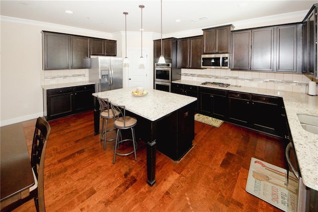 4594 Marching Ln, Fairburn, GA 30213 - kitchen with a center island, pendant lighting, dark wood-style flooring, appliances with stainless steel finishes, and light stone countertops