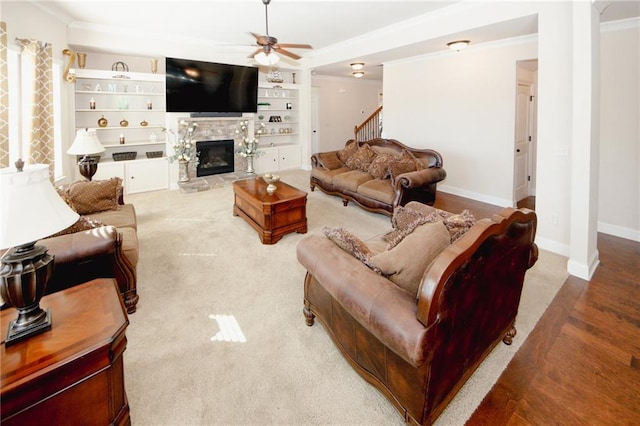 4594 Marching Ln, Fairburn, GA 30213 - living room featuring baseboards, a ceiling fan, crown molding, built in shelves, and a fireplace