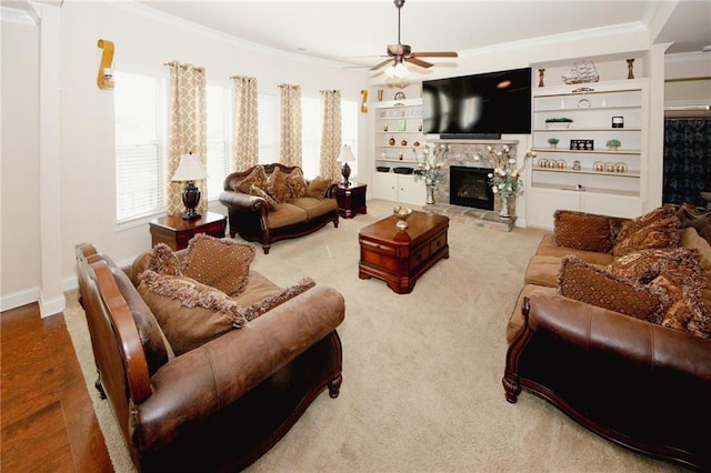 4594 Marching Ln, Fairburn, GA 30213 - living area featuring baseboards, built in features, a ceiling fan, crown molding, and a stone fireplace