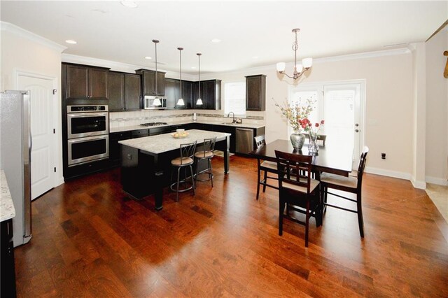 4594 Marching Ln, Fairburn, GA 30213 - kitchen with tasteful backsplash, a kitchen breakfast bar, a center island, stainless steel appliances, and pendant lighting