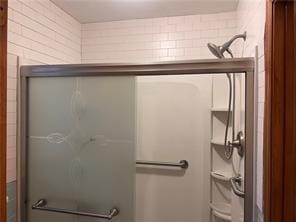 bathroom with a shower with door