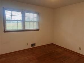 spare room featuring hardwood / wood-style floors and a wealth of natural light