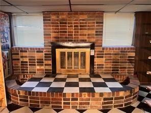 unfurnished living room featuring a fireplace and a drop ceiling