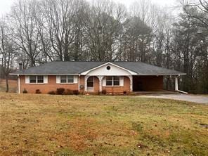 single story home with a front yard and a carport