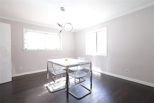 dining room with dark hardwood / wood-style flooring, crown molding, and a healthy amount of sunlight