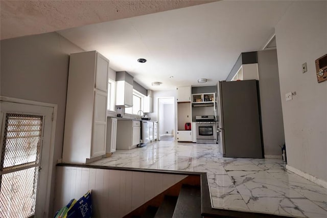 kitchen featuring white cabinetry, sink, stainless steel appliances, and a textured ceiling