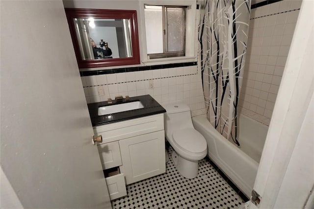 full bathroom featuring vanity, decorative backsplash, toilet, shower / bath combo with shower curtain, and tile walls