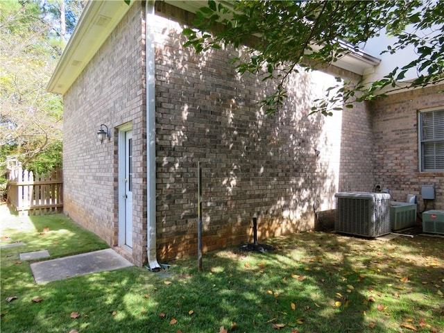 view of home's exterior with a yard and central AC unit