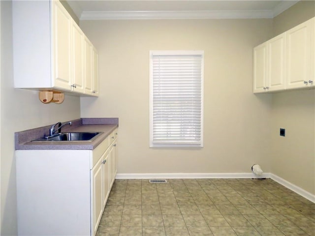 laundry area with crown molding, electric dryer hookup, cabinets, and sink