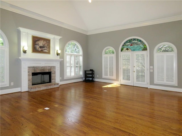 unfurnished living room with lofted ceiling, dark wood-type flooring, a fireplace, and crown molding