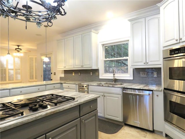 kitchen with white cabinets, decorative light fixtures, and stainless steel appliances