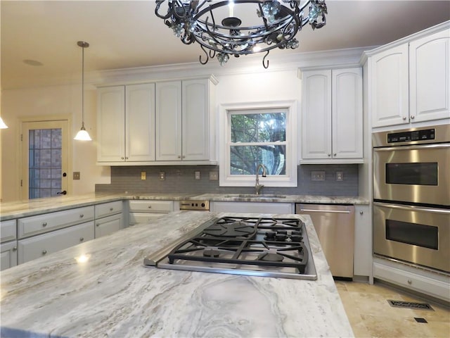 kitchen with appliances with stainless steel finishes, decorative backsplash, white cabinets, and sink