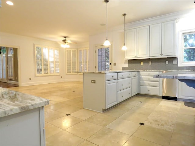 kitchen featuring hanging light fixtures, backsplash, light stone countertops, white cabinetry, and ceiling fan