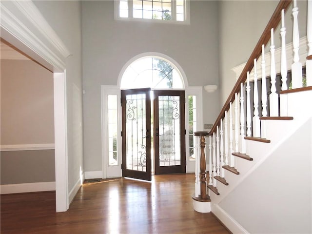 foyer featuring a towering ceiling, french doors, and dark hardwood / wood-style floors