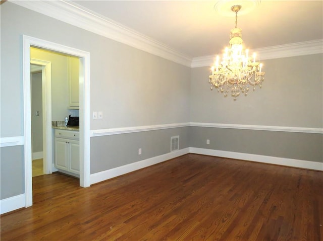 unfurnished room featuring ornamental molding, a notable chandelier, and dark hardwood / wood-style flooring