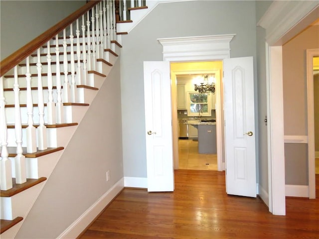 stairs with a notable chandelier and hardwood / wood-style floors