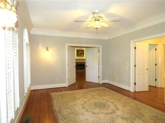 unfurnished bedroom with ceiling fan, crown molding, and dark hardwood / wood-style floors