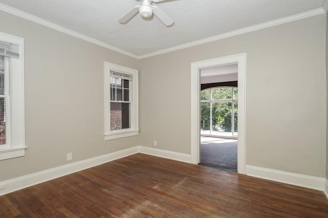 empty room featuring ornamental molding, dark wood finished floors, and baseboards