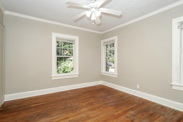 spare room featuring crown molding, baseboards, and wood finished floors