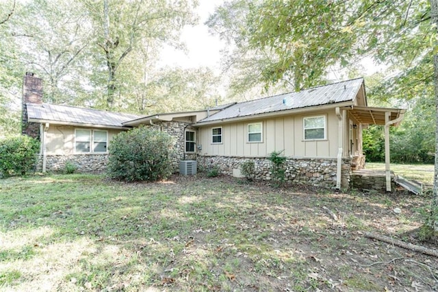 back of house featuring a yard and central air condition unit