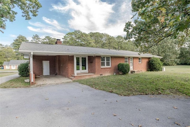 ranch-style home with a carport, a front yard, and french doors