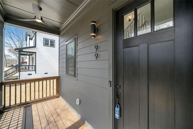 view of exterior entry featuring ceiling fan and covered porch