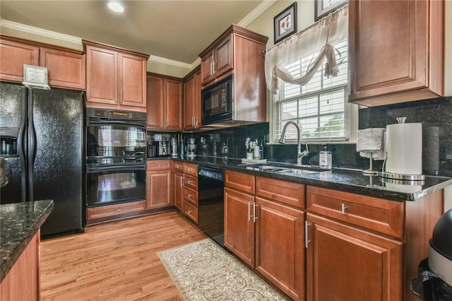2727 Lost Mill Trce, Buford, GA 30519 - kitchen featuring a sink, dark stone countertops, light wood-type flooring, crown molding, and black appliances