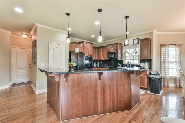2727 Lost Mill Trce, Buford, GA 30519 - kitchen with tasteful backsplash, light wood-style floors, black appliances, a kitchen bar, and baseboards
