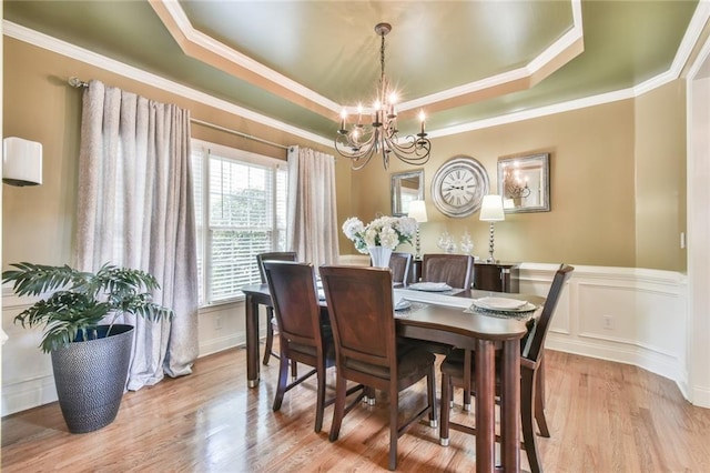 2727 Lost Mill Trce, Buford, GA 30519 - dining area featuring a chandelier, a wainscoted wall, a tray ceiling, ornamental molding, and wood finished floors