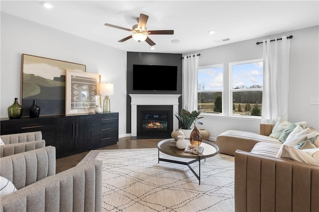 living room featuring ceiling fan, recessed lighting, visible vents, light wood finished floors, and a glass covered fireplace