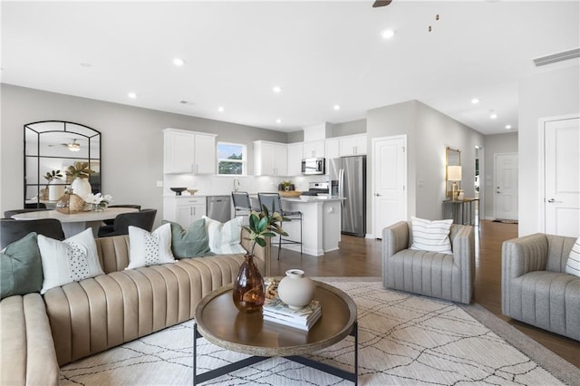 living room with recessed lighting, visible vents, ceiling fan, and light wood finished floors