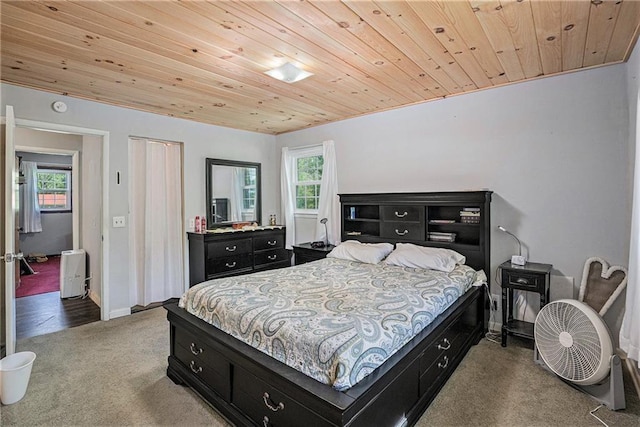 bedroom featuring baseboards, carpet flooring, and wood ceiling